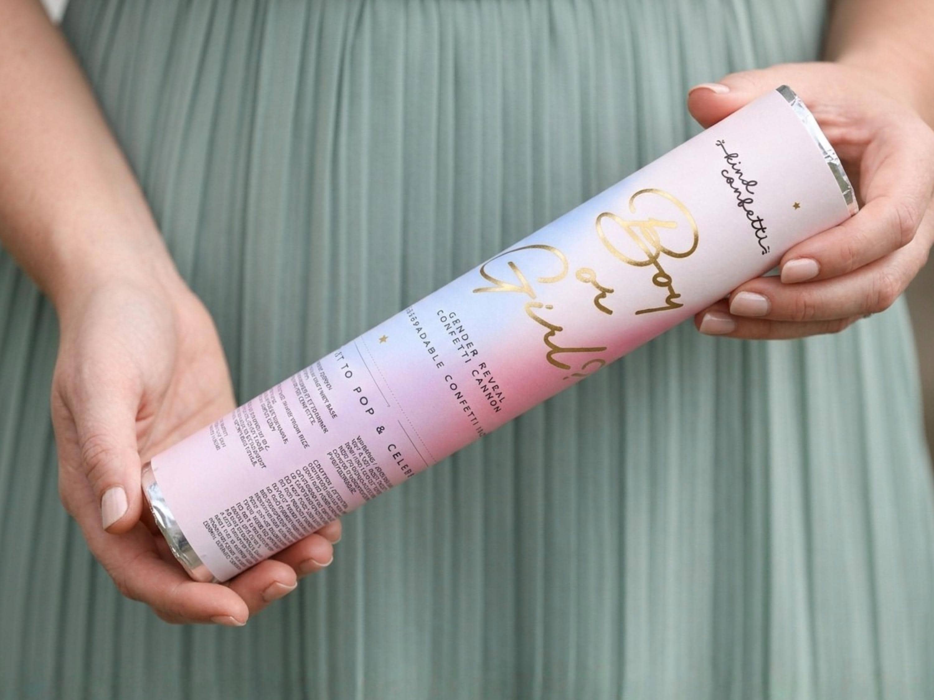 Hands holding a 12 inch gender reveal confetti cannon, ready to twist and pop